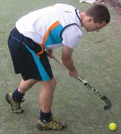 Using a shoveling action to propel the ball towards the goal.
