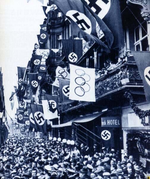 The spectators of the games in Berlin in 1936 see not only the Olympic flag waving in the air, but also many flags with the swastika, a good example of the Nazi propaganda at the games.