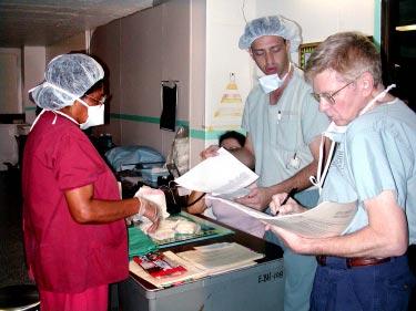 (Photo by Jim Bennett) Nurses Mili Masiasa, left, and Sgt. Shawn Woffard,center, go over patient files with Dr. (Col.) Weldon Dunlap, an opthamologist with Tripler Army Medical Center.