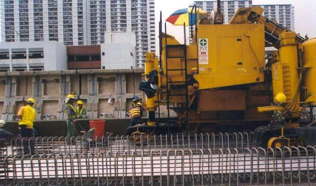 Forming the side curb using a track-mounted curb-forming machine.