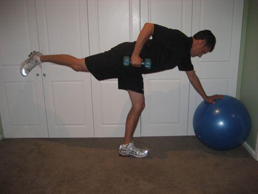 dumbbell in the opposite hand to the stance leg The golfer balances their weight through their other hand on a bench or