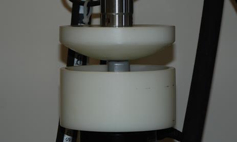 The MTS was used with a custom adaptor interface to impact helmet padding samples. Tests were performed using custom designed curved adaptors to support and impact helmet padding (Figure 12).