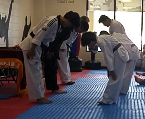 Bowing should be performed with the heels together, hands open at your side with fingers together (or closed in a fist) and shoulders pulled back bowing from the waist. The eyes should look downward.