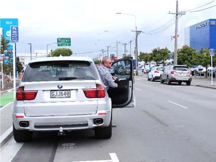 Photo 9: Example of larger SUV overhanging parking space. Note door into edge of traffic lane.