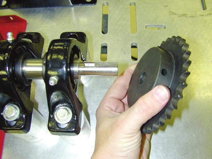 D. Carefully pull the sprocket off the driven shaft, as shown in figure 44. If the sprocket is stuck, use a small punch and tap the key out of the keyseat, or use a gear puller.