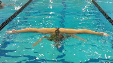 Right kneecap faces toward the bottom of the pool, while the Left kneecap faces up parallel to the surface.