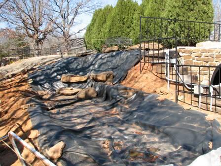 In the first picture below, the underlayment and the rubber outlining the courses of the falls and stream are in place.