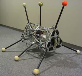 a b Fig. 2. The physical robot and the experimental bay. a: The physical robot. b: The experimental bay. Note the external camera used to compute the fitness of a gait.