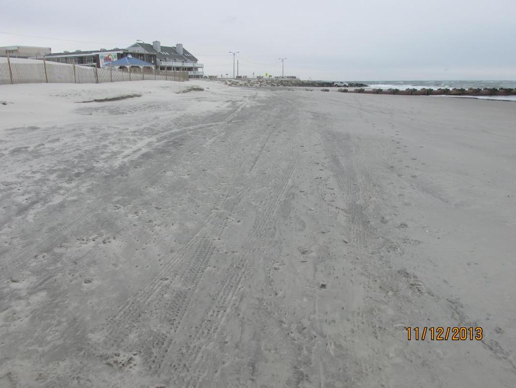 Sand placement had raised the elevation of the beach and created a dry beach berm that extended approximately 100-200 feet seaward of the revetment and dune toe.