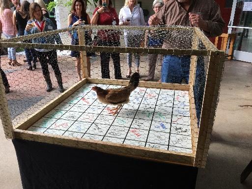Participants choose squares on a large game board, while spectators watch