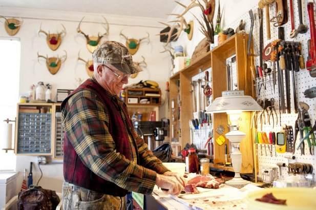 Caption: Don Beusman of Canandaigua processes a doe that he harvested during archery season.