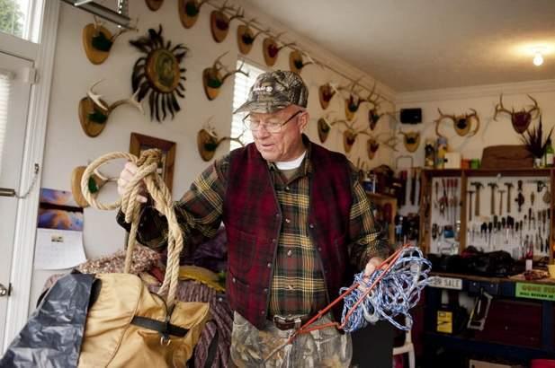 Caption: Don Beusman of Canandaigua packs his rope and block & tackle into a backpack.