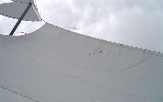 Like the main, be conscious of not over tensioning the jib halyard. However, never allow the jib halyard to be eased enough that there are scallops between the snaps.