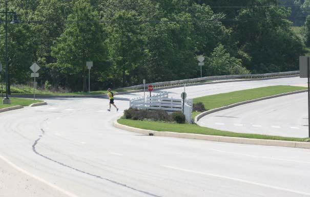 A pedestrian uses the mid-block crossing feature on the Chester Valley Trail in West Whiteland Township. PennDOT encourages these same criteria for locally owned roadways.