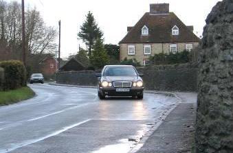 Adverse camber on sharp bend, cars often mount the pavement and