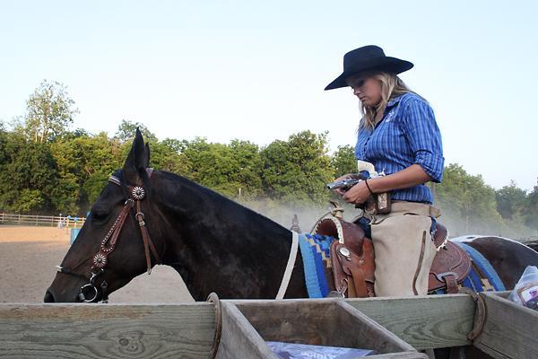 Katie Smith loads her gun before cowboy mounted shooting practice July 6.