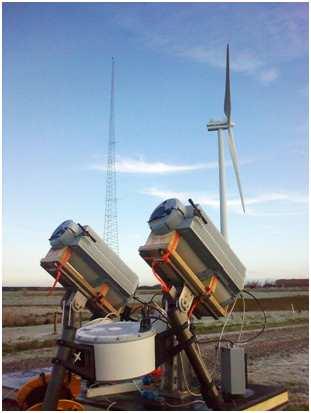 Figure 5: Two CW wind lidars belonging to the Windscanner.dk research facility being intercompared and tested up against the tall meteorological masts at Høvsøre, Risø DTU.