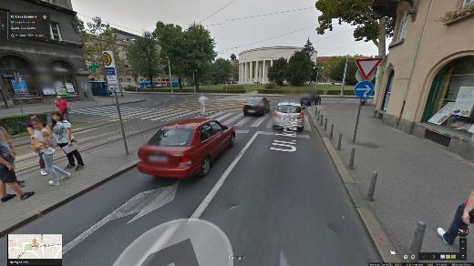 The tram stop is not equipped with a safety fence, allowing the pedestrians to cross the road beyond the crosswalk.