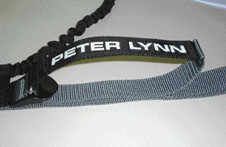 Pull the black end of the loop (the end with the Peter Lynn logo) towards you and release forward. The clip slides away in small steps. Repeat the process until you find the right setting.