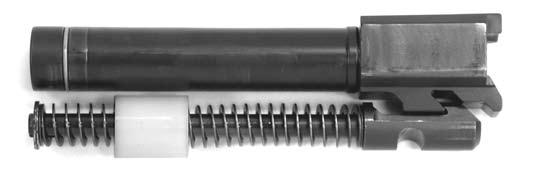 of the slide; the locking block portion of the barrel fits within the ejection port, and the angled locking surfaces of the locking block are visible along the bottom of the slide.