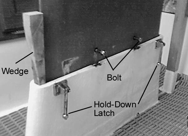 hold-down latches and drop them to the side of the daggerboard trunk.