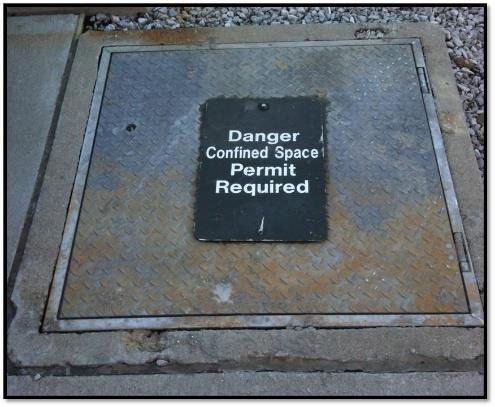 A sign reading DANGER -- PERMIT- REQUIRED CONFINED SPACE, DO NOT ENTER or using other similar language would satisfy the requirement for a sign.