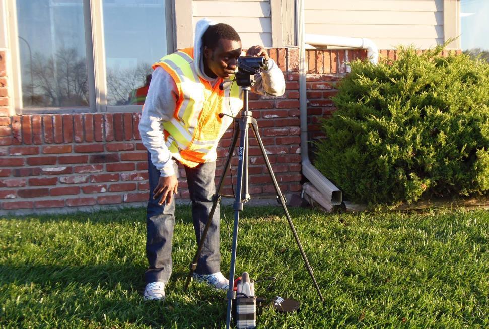 Figure 4.32 A member of the research team setting up a camera to record RLR violations. A member of the research team would monitor the cameras at the intersection from a vehicle parked close by.