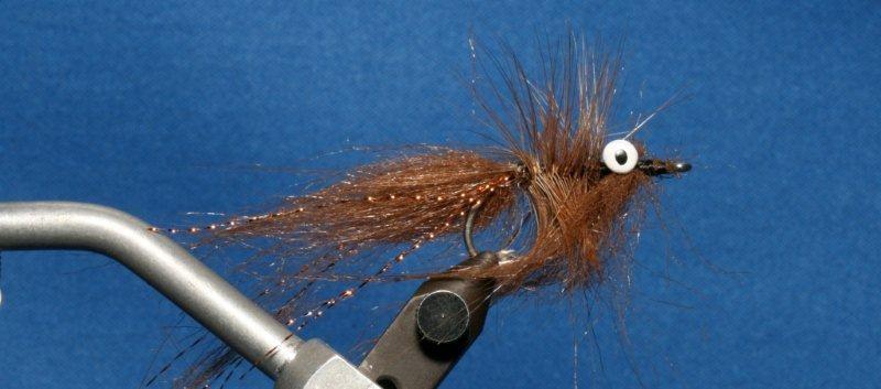 Attach both tips together with hackle pliers and palmer the hackles around hook to just behind eyes.