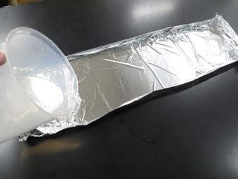 Fold up the edges so that it can hold water. Fill it with water. 3. Put the boat at one end of the foil. Use a straw to blow it to the other end.