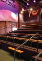 seating and a large screen at the front of the room. The Hall of Fame Theater holds 90 guests, theater style on benches.