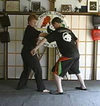 Right hand hooks behind neck, pulling opponent face into left knee then a