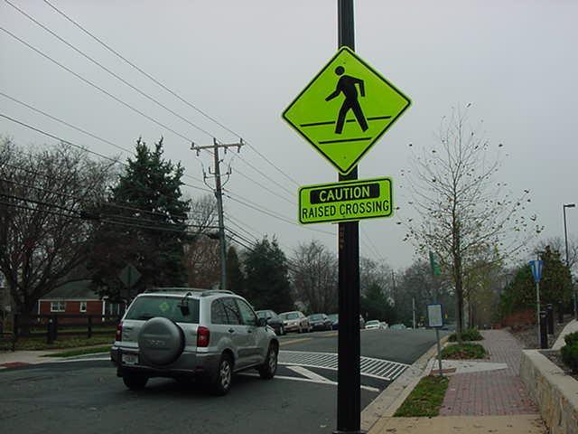 RAISED CROSSWALK Description: Raised crosswalks are essentially flat-top speed tables which are installed across the roadway to prompt drivers to exercise caution (slow down) in a recognized and