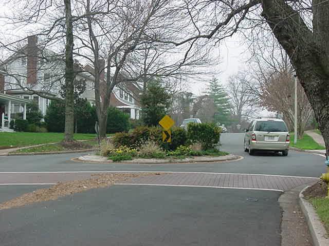 TRAFFIC CIRCLE Description: A traffic circle is a small island, usually landscaped, placed in the middle of an intersection on a neighborhood street.