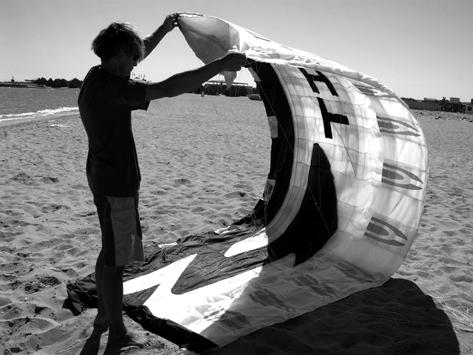Weight down the kite with sand (if available, if not any none piercing or