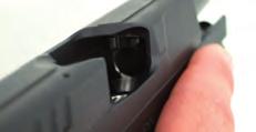 Grasp the slide from the top, in front of the rear sight, and remove the