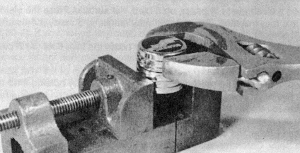 Use a 15" adjustable wrench and a bench vise to separate the cap from the adjusting ring (see Photo # 4). Photo #4 10. Remove the piston 24 and spring 21 from the cap. 11.