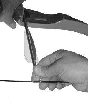 Handle the arrow by the nock to load when the bow is hanging at your side.
