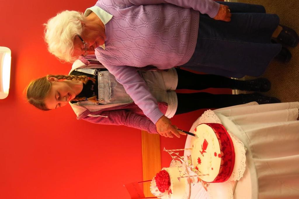 (right) Toft resident Lilia Tynan (12) cuts the specially made WWII Across the Generations commemorative cake.