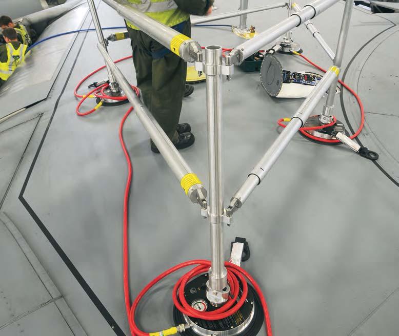 Here, the anchor is positioned and vacuum-locked in place, then used by a worker wearing a full-body harness with a safety lanyard and work positioning rope, connected to the vacuum anchor.