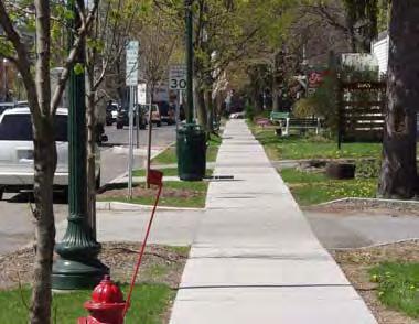Curbs: Recommended on all sidewalks to provide a physical barrier between vehicle traffic and people walking. Drainage can be provided through inlets or gaps in curbs.