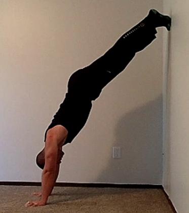 This exercise is called the walk up to a face the wall handstand. To perform the walk up to the face the wall handstand, start in the same position that you had in the elevated plank.