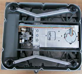 The next step entails breaking the warranty sticker (105): - Remove the 10 screws (E) that fasten the cover plate (104). - The weighing system is now accessible. 107 F Aut13876.jpg Aut_5873a.