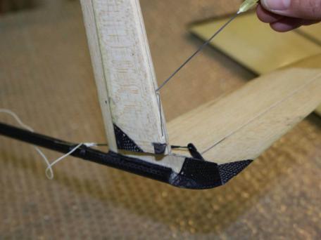 Stick the spring into the wood. Then harden these spots with super glue.