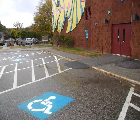 An accessible route with a flush curb is required Cross slope of the parking spaces appears to exceed