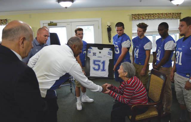 Xenia football coach Trace Smitherman shakes Edna Adams hand, during the June 15 surprise presentation of a No.