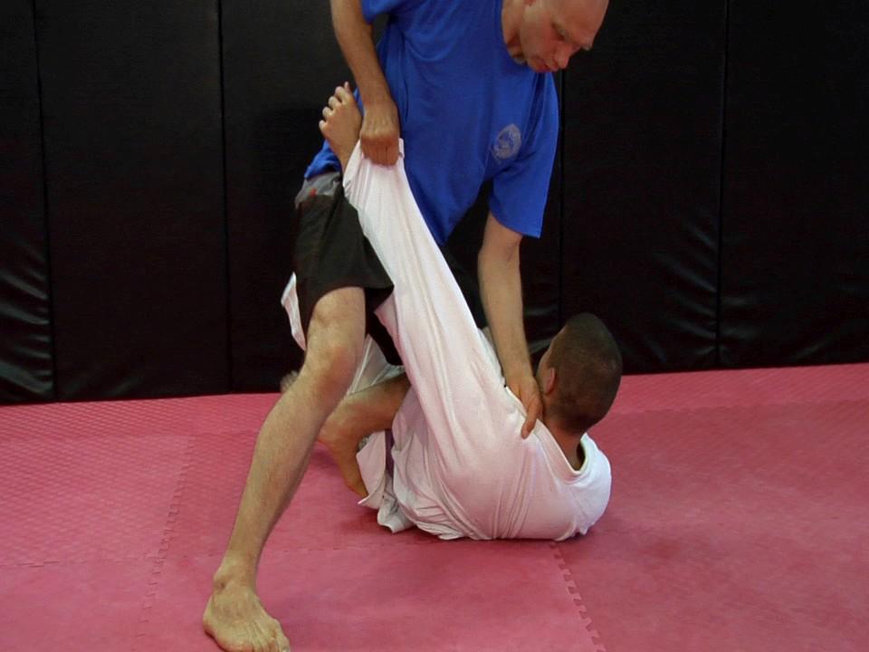 In the classic Knee Mount position with the gi we often grab deep into the collar and hold onto the sleeve.