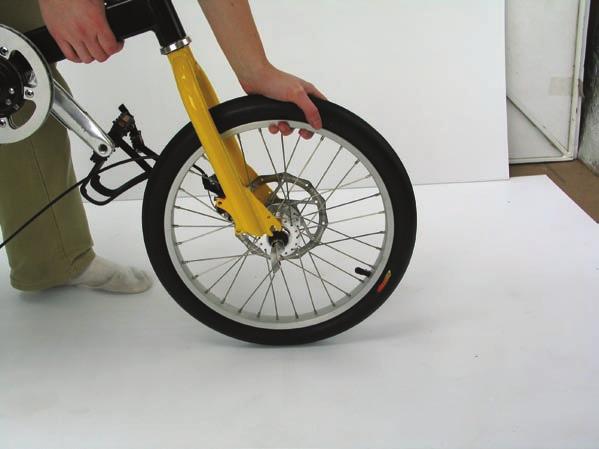 Unscrew the nut & slide it through the axle from the opposite side to the disc, then screw the nut on until the end of the