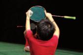 Holding a racket near the T with the first finger below and along the frame.