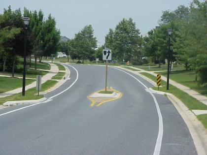 They are curb extensions or islands that alternate from one side of the street to the other, forming S-shaped curves.