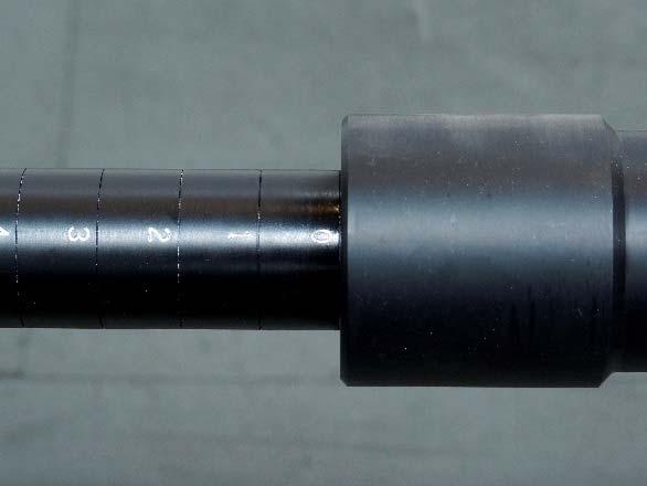 2 Retract tap depth indicator (boring bar) to 0 inches by utilizing the ratchet handle to rotate it counter clockwise while restraining both the